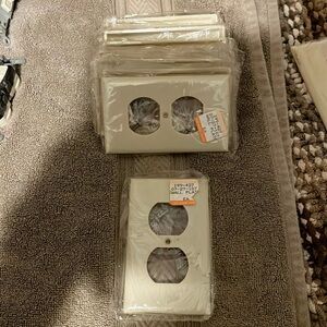 29 receptacle plates cream color with screw in plastic unused undamaged dusty
